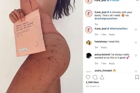En person står med ryggen til og holder en skønhedsproduktpakke fra frank_body, mens de viser huden med exfolierende scrubs.
