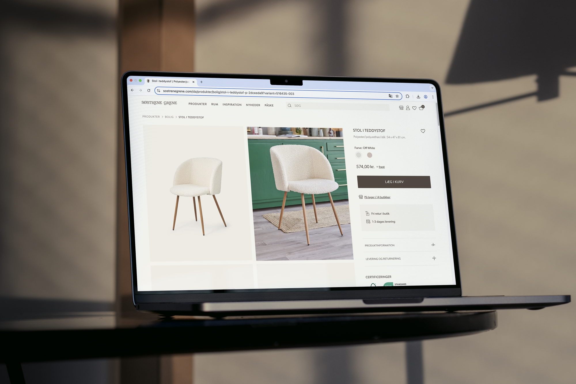 En moderne stol i teddystof med let buede arme og tre ben af træ, præsenteret på en skærm med produktinformation og detaljer.