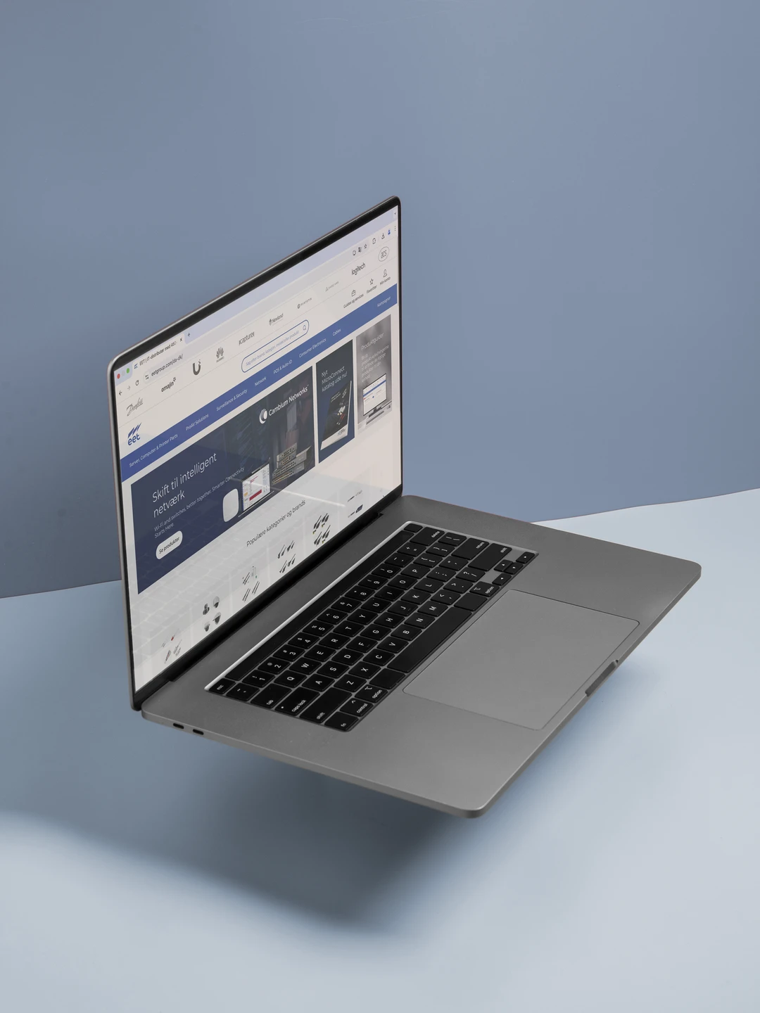 En bærbar computer svævende over en blå baggrund, med en åben skærm der viser en hjemmeside med information om intelligent netværk.