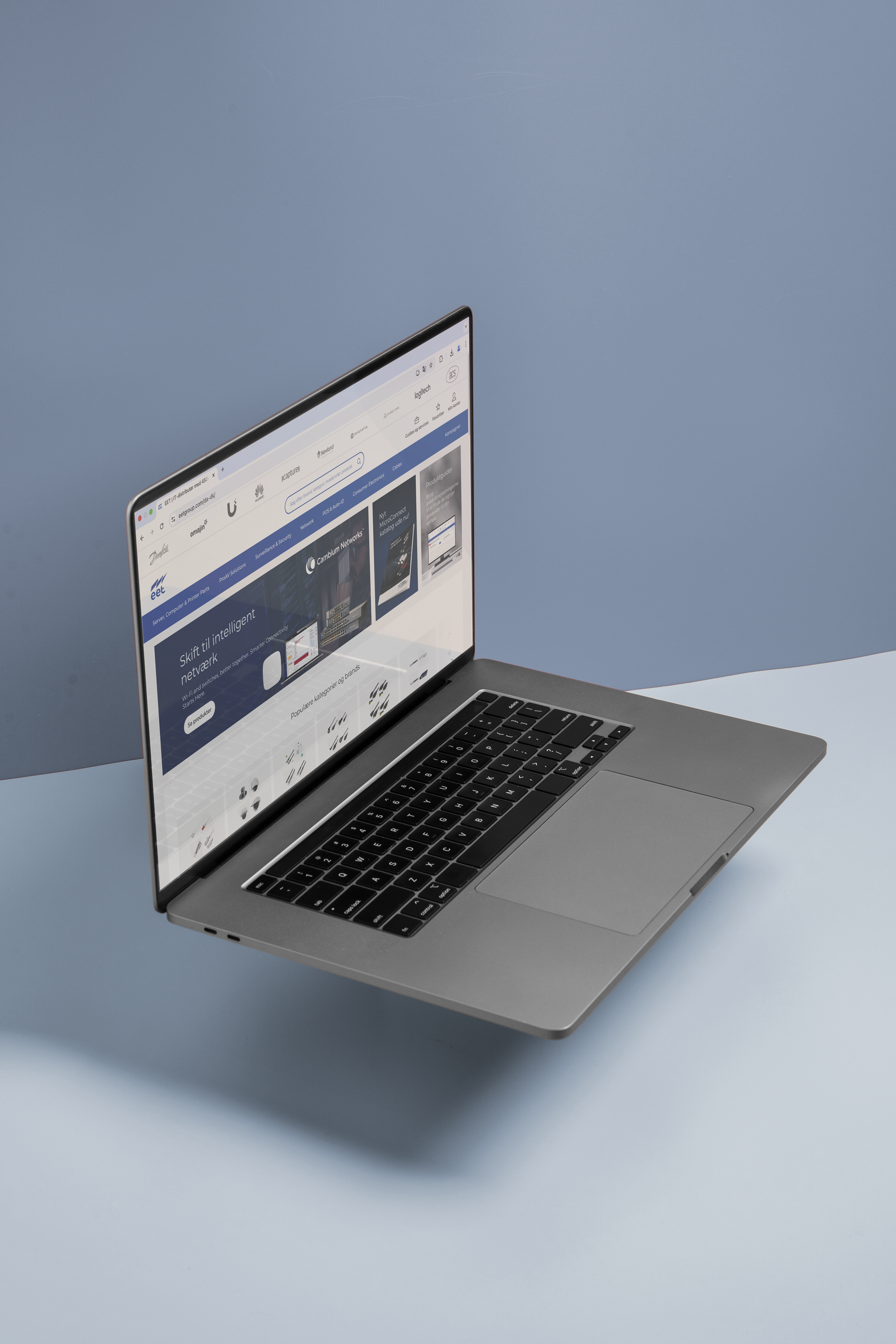 En bærbar computer svævende over en blå baggrund, med en åben skærm der viser en hjemmeside med information om intelligent netværk.