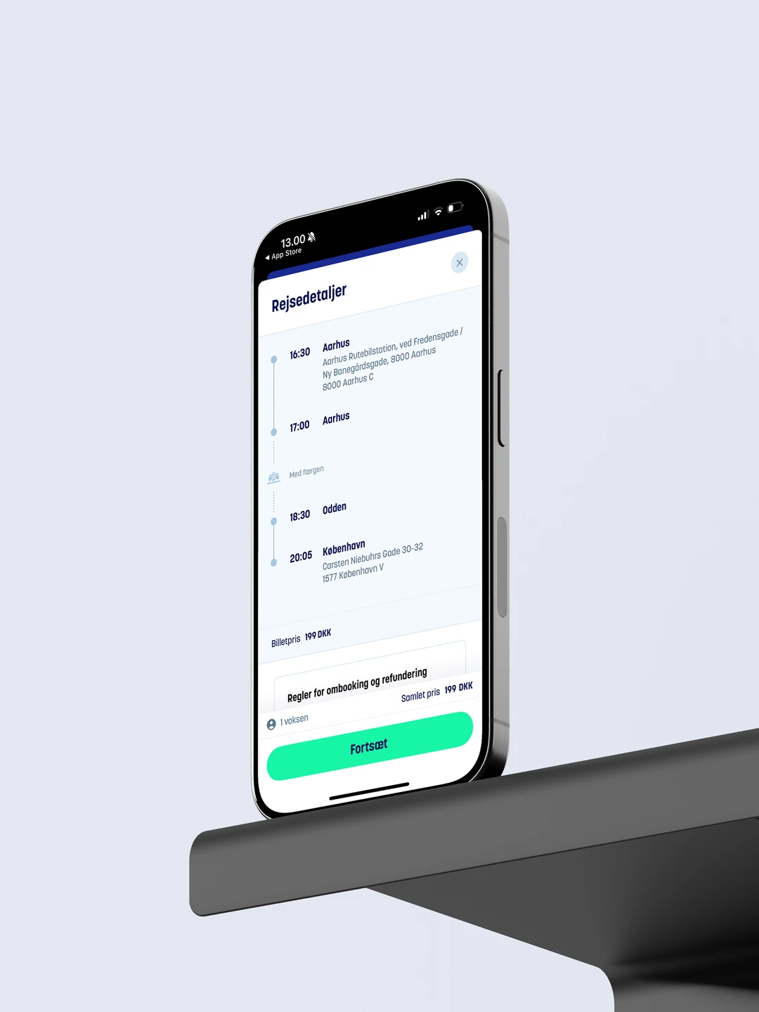 Smartphone med rejseinformationer, inklusive afgangstider fra Aarhus til København, placeret på en bordkant.