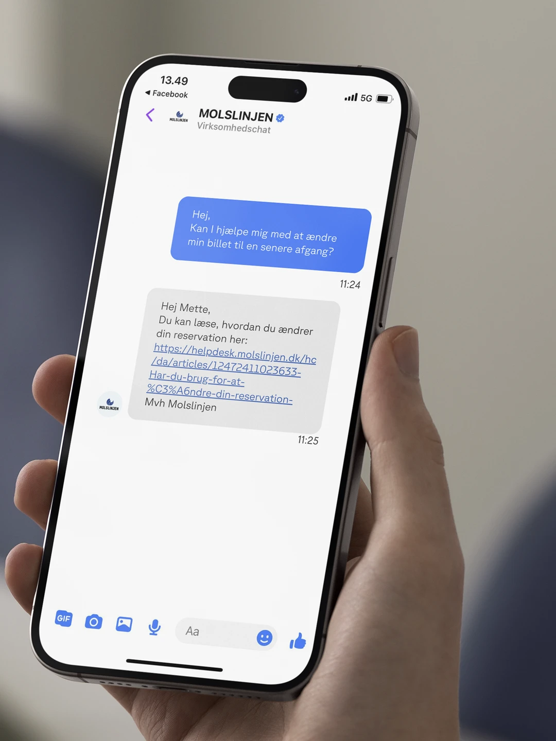 A person holding a smartphone displaying a Facebook Messenger conversation, featuring a customer service interaction about changing a ticket reservation, with visible timestamps and a helpful link.