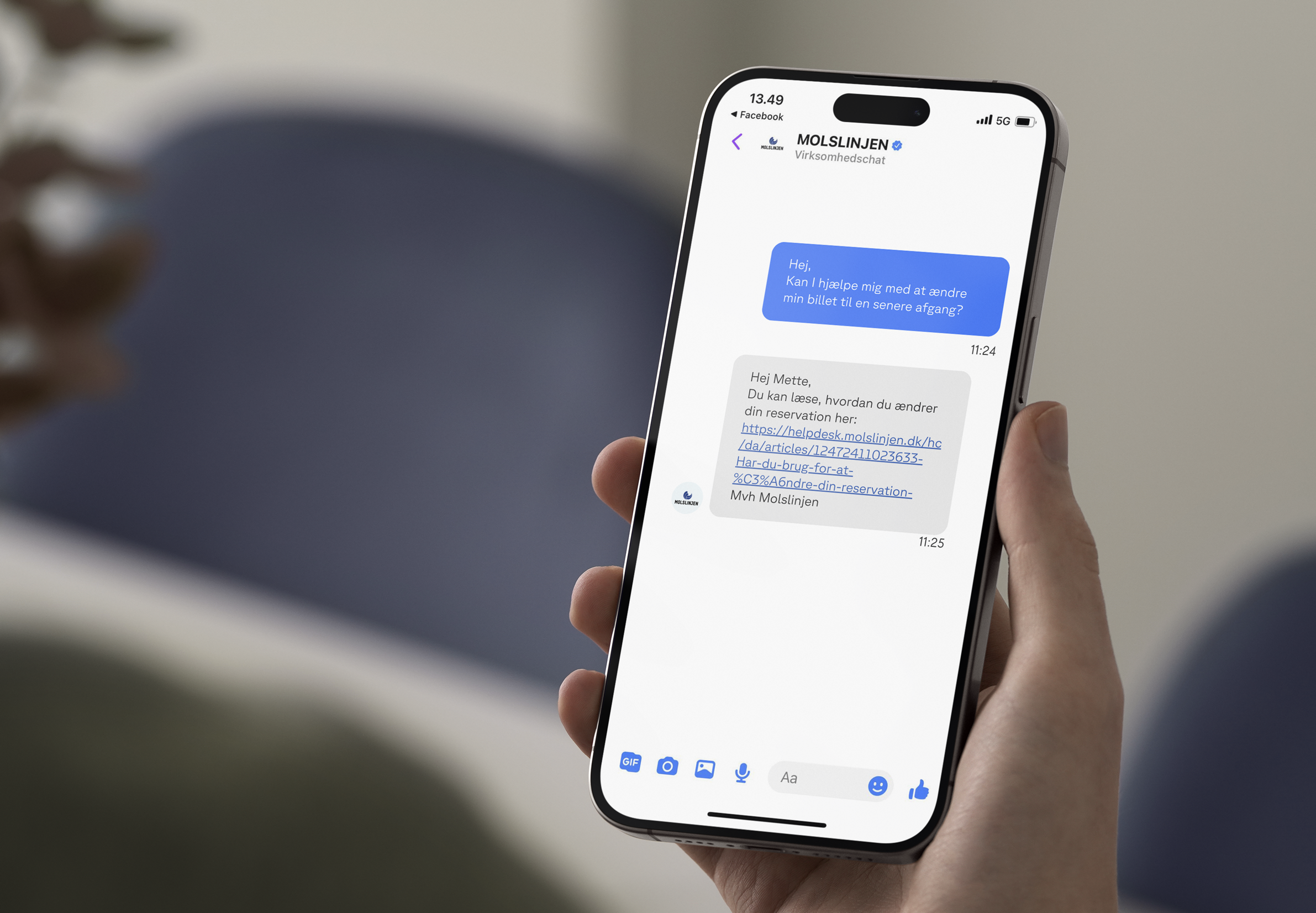 En person holder en smartphone, der viser en chatbesked fra Molslinien, der tilbyder hjælp til at ændre en reservation.