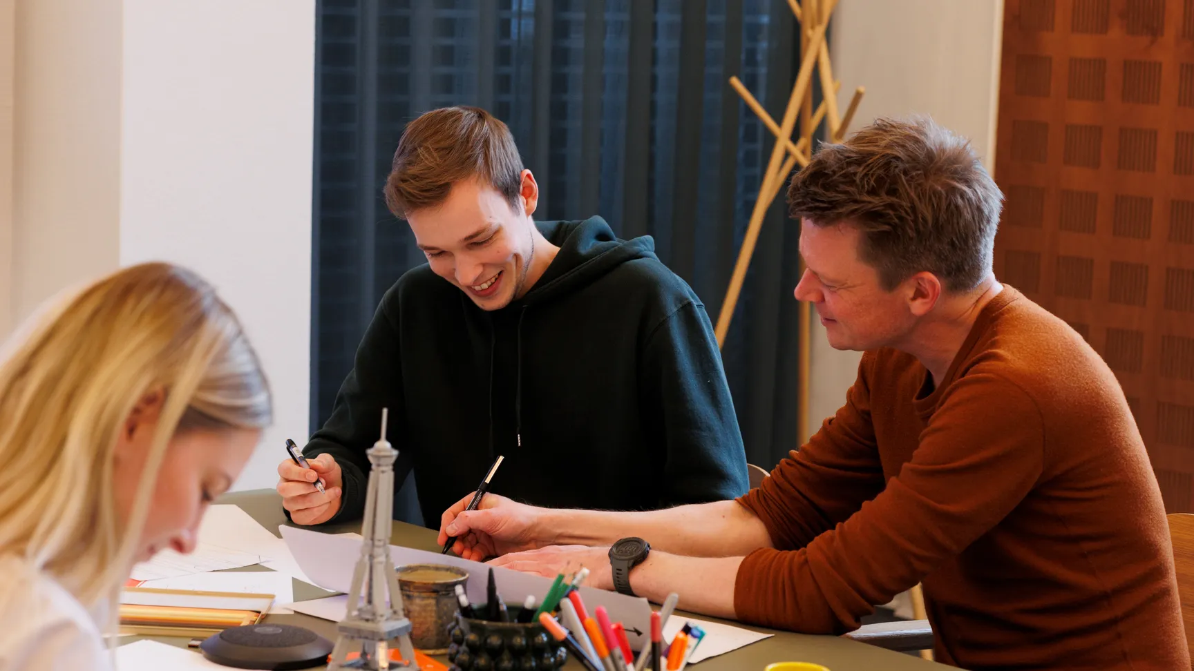 UX skteching workshop, hvor en kollega hjælper en anden med at tegne et UX-flow
