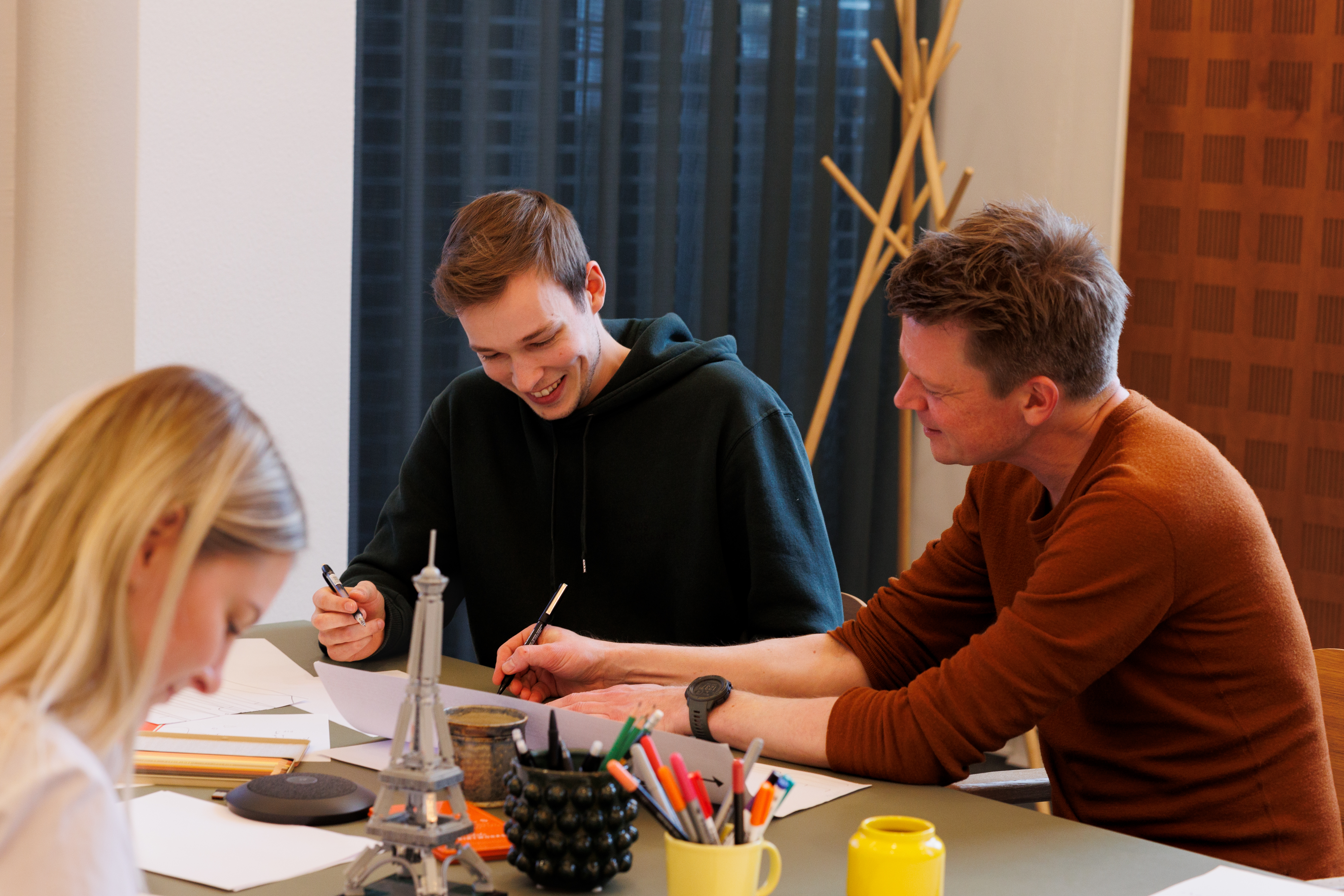 UX skteching workshop, hvor en kollega hjælper en anden med at tegne et UX-flow