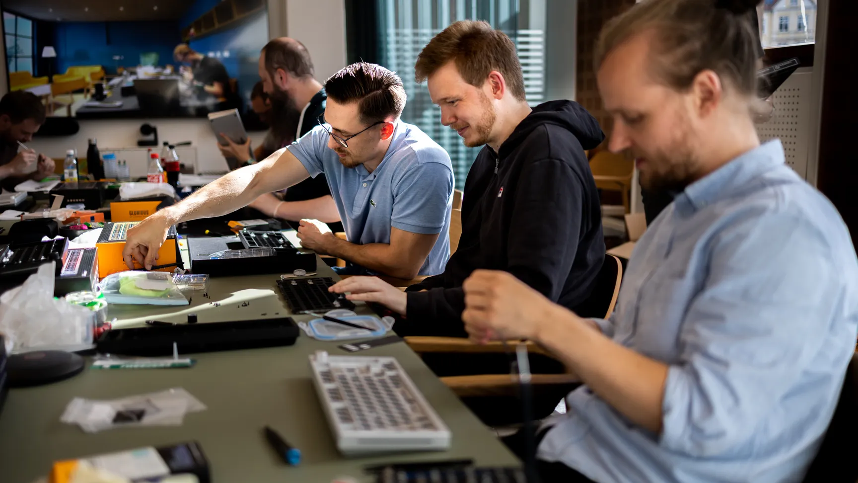 Kollegaer sidder rundt om et bord og designer deres egne personlige keyboards