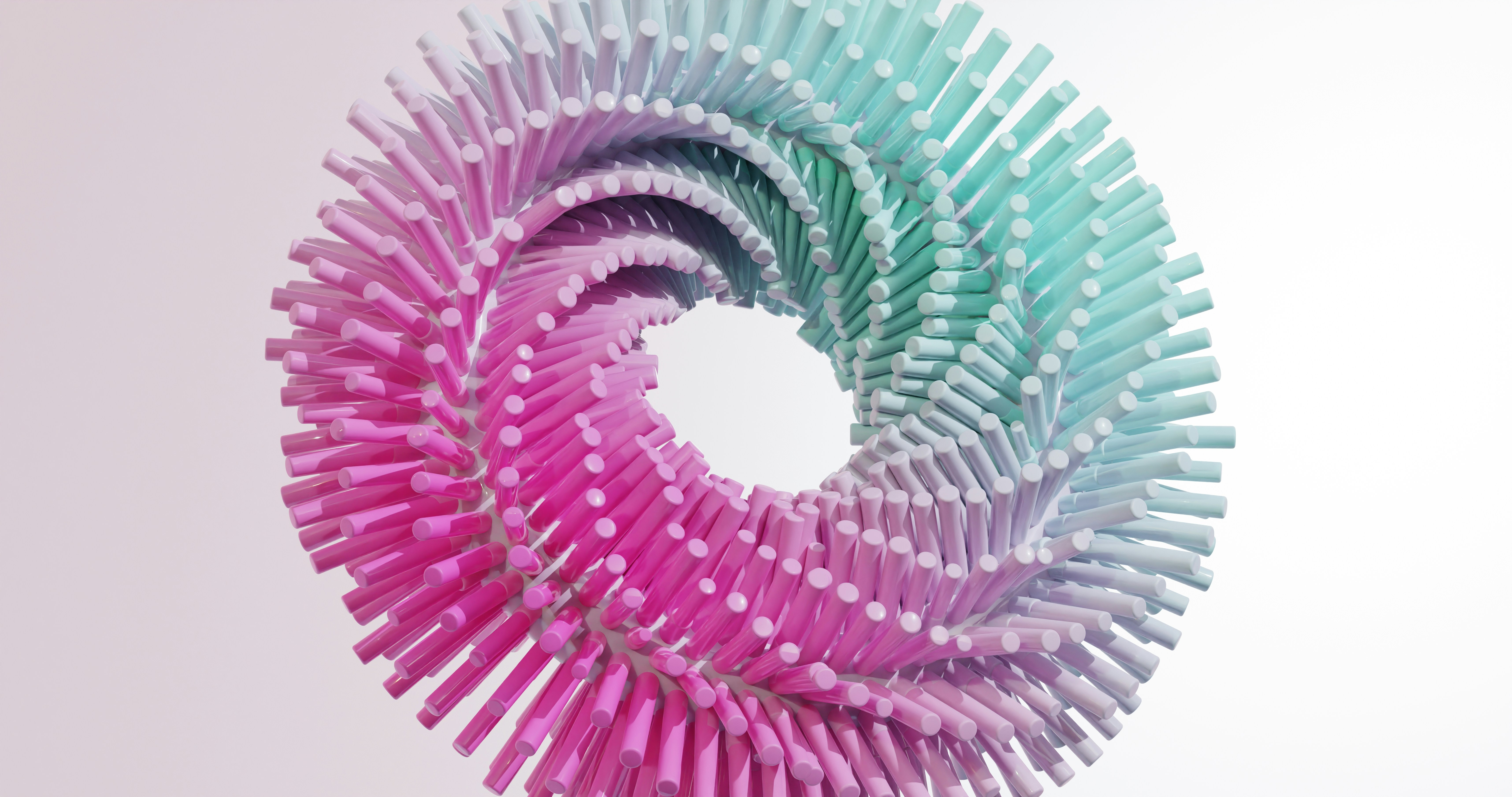 Farverig spiral formet skulptur lavet af cylindriske elementer i nuancer af pink og mintgrøn, set mod en hvid baggrund.