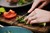 Hænder snitter aspargesbroccoli på spækbræt købt via Coops B2C digitale salgskanaler på både web og app 